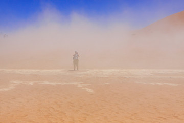 Namib Naukluft national Park / Local sandstorm on the dead lake plateau. In the depths of the sandstorm is a tourists