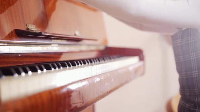 A child opening a piano cover