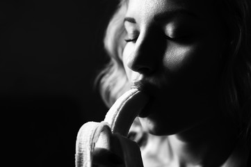 Portrait of a girl with a banana on a black background