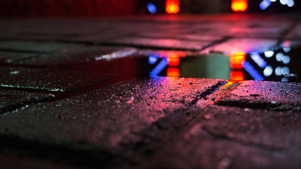 Background of wet asphalt with neon light. Blurred background, night lights of a big city,...