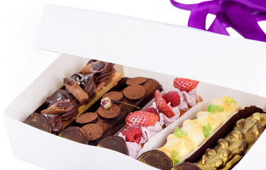 A box of delicious desserts. Eclairs with different fillings. Delicious desserts in the packaging box.