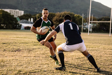 Rugby players tackling during game - Powered by Adobe