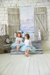 Cute little girls in studio with sea scene location