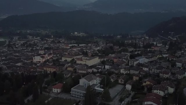 Aerial reveal type clip of Levico Terme, Italy, during sunrise with drone flying forward