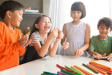 Asian kids playing with play colorful clay at home or kindergarten or playschool