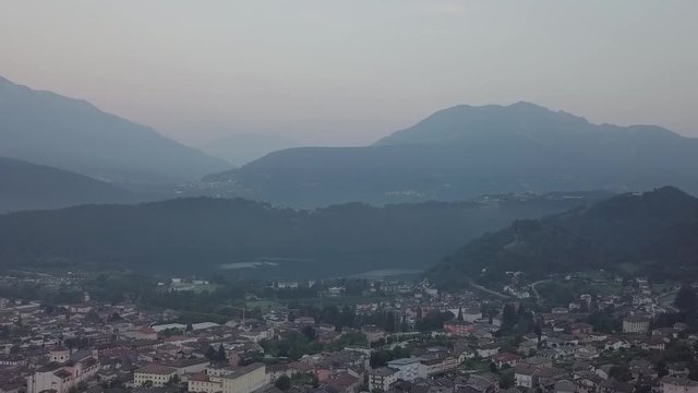 Aerial panoramic view of Levico Terme, Italy, during sunrise with drone panning right to left
