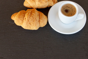 Mini croissant next to a cup of greek coffee