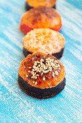 Baked seafood rolls lie in a row on a blue background