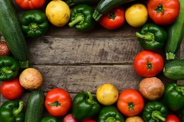 Cucumbers, tomatoes and sweet pepper on wooden table for background