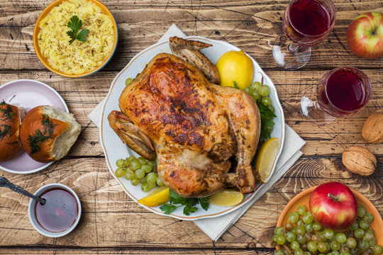 Baked chicken, mashed potatoes and wine glasses for dinner on the festive table.