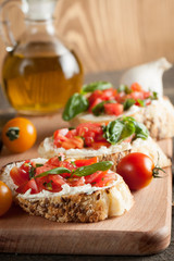 Italian tomato and cheese bruschetta. Tapas, antipasti with chopped vegetables, herbs and oil on grilled ciabatta and baguette bread.