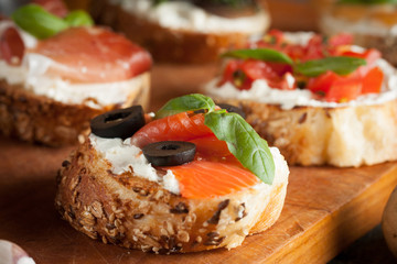 Italian tomato and cheese bruschetta. Tapas, antipasti with chopped vegetables, herbs and oil on grilled ciabatta and baguette bread.
