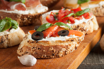 Italian tomato and cheese bruschetta. Tapas, antipasti with chopped vegetables, herbs and oil on grilled ciabatta and baguette bread.