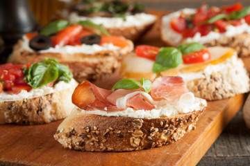 Italian tomato and cheese bruschetta. Tapas, antipasti with chopped vegetables, herbs and oil on grilled ciabatta and baguette bread.