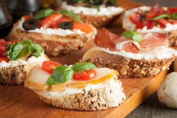 Italian tomato and cheese bruschetta. Tapas, antipasti with chopped vegetables, herbs and oil on grilled ciabatta and baguette bread.