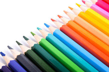 Many different colored pencils on a white background with a place for text and cory space .