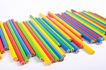 Many different colored pencils on a white background with a place for text and cory space .