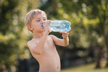 Six yeras old boy drinking water in the garden © Dziurek