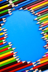 Fototapeta premium Colored pencils background.Color pencils on blue background.Close up. Many different colored pencils on blue background.Colorful pencil .Colorfull