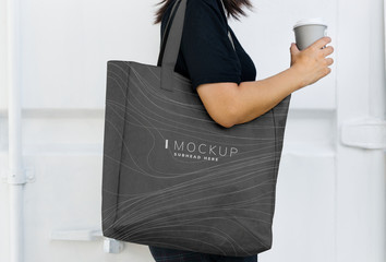 Woman carrying a black shopping bag mockup - obrazy, fototapety, plakaty