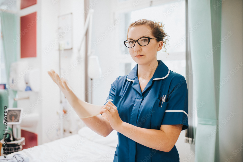 Wall mural female nurse putting on a glove