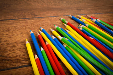 Different colored pencils on the brown wooden table background .Top view .Close up .Color .Pencil.Set