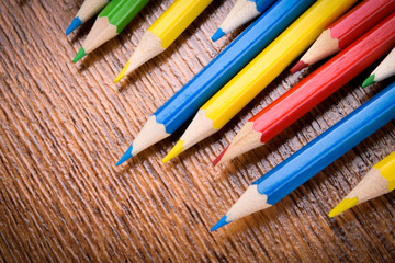 Different colored pencils on the brown wooden table background .Top view .Close up .Color .Pencil.Set