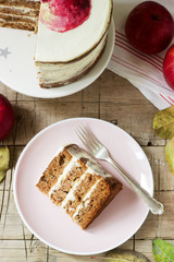 Apple cake with curd cream, decorated with painted apple on the background of autumn composition. Rustic style.