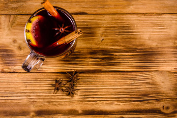 Cup of mulled wine with cinnamon on wooden table. Top view