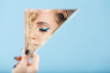 Woman looking at her self reflected in a mirror