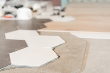 The combination of wood panels of laminate and ceramic tiles in the form of honeycomb. Kitchen renovation. concept of repair in house.