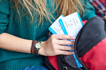 Woman hand put a boarding pass in bag. Hand holding tickets. Waiting for aircraft and travel