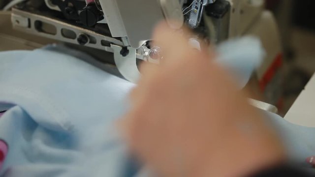 Woman's hands sewing an overlock at sewing machine. Overlock stitch on sewing machine. Automatic sewing machine. Close-up