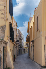 Narrow street in the old part of the Greek city with characteristic southern architecture