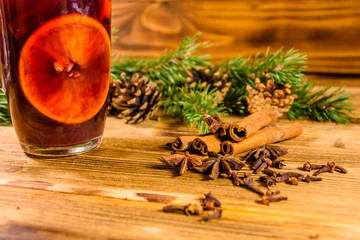 Cup of mulled wine with cinnamon and fir tree branches on wooden table