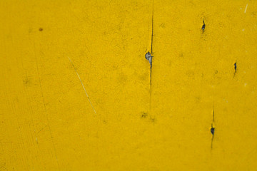 Yellow paint on old distressed wooden background