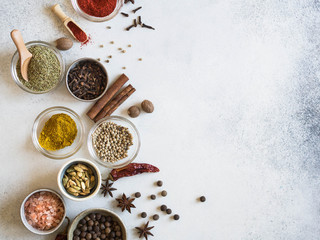 Various spices in bowls on the table. dry herbs, salt spices on a gray background.