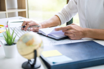 Businessman working writing making note business plan and graphic designer with computer in office