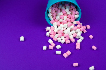 marshmallow laid out on violet paper background.