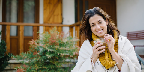Relaxed woman drinking hot coffee cup outside on autumn. Tranquility at home concept.