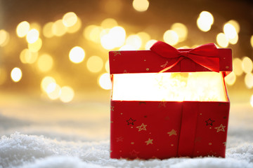 Weihnachtsgeschenk im Schnee mit Bokeh Hintergrund