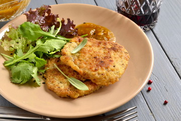 Fried pork chop with fresh herbs and fruit sauce