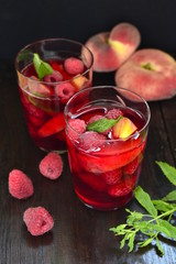 Lemonade with raspberries, peaches and mint, vertical