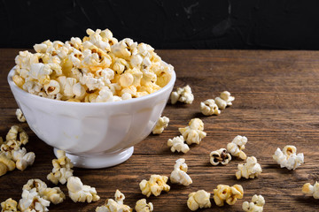 Air salty popcorn.A bowl of popcorn on a wooden table.Salt popcorn on the wooden background .  With space for text.Top view.popcorn texture.Chees .