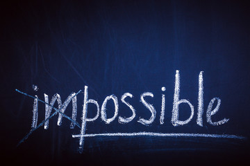 impossible concept written in white chalk on a blackboard