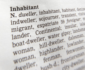 CLOSE UP OF DICTIONARY PAGE SHOWING DEFINITION OF THE WORD INHABITANT