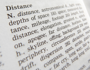 CLOSE UP OF DICTIONARY PAGE SHOWING DEFINITION OF THE WORD DISTANCE