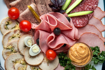 Fototapeta na wymiar Cold smoked meat plate with prosciutto, salami, bacon, pork chops, cheese and olives on gray stone background.