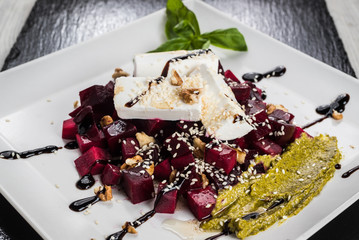 Healthy raw vegan salad with beetroot, cheese and pesto