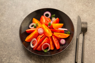 Fresh tomato salad with onion, parsley, spices and olive oil